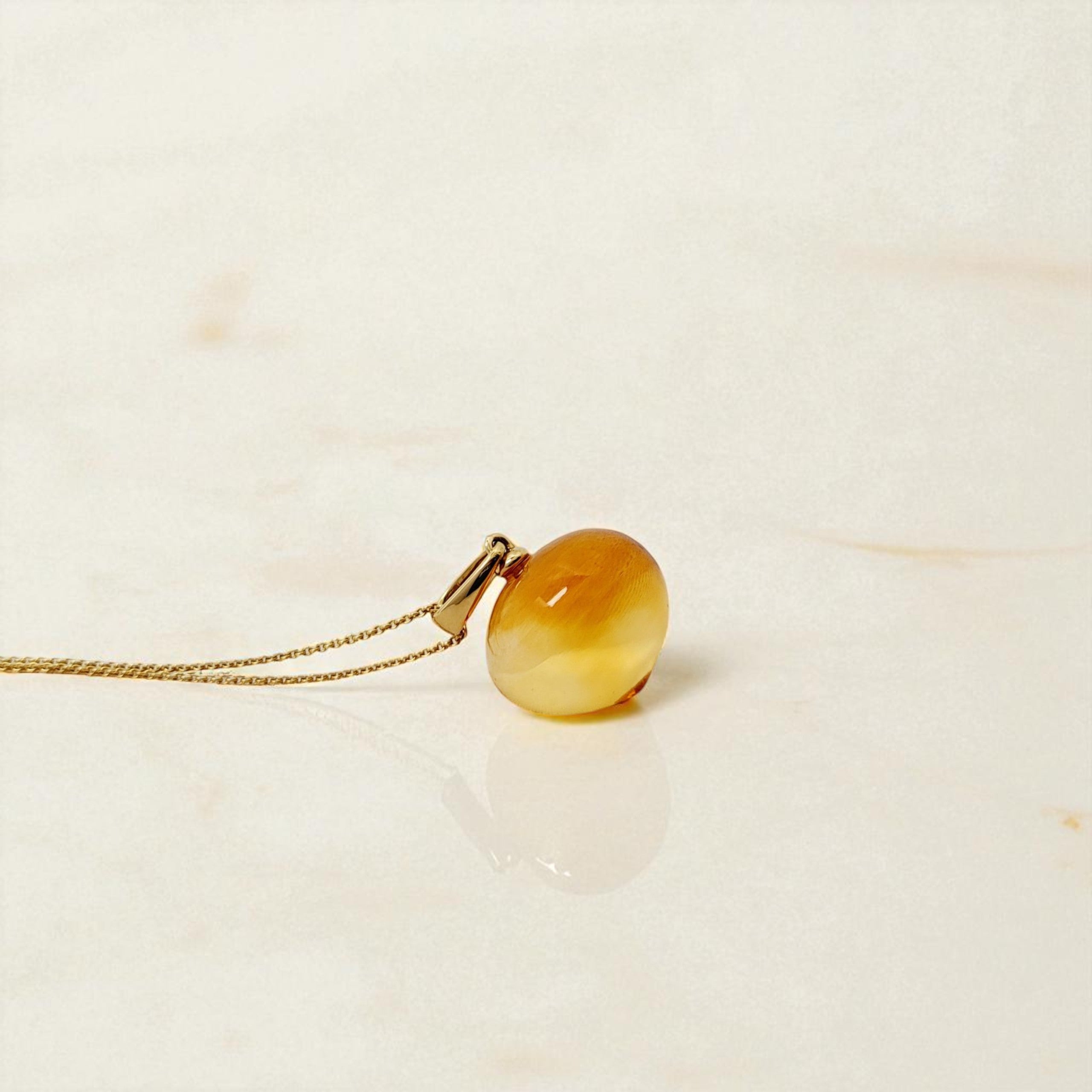 Edelsteinanhänger Citrin 22mm mit Halskette aus 585 Gold auf beigem Marmor