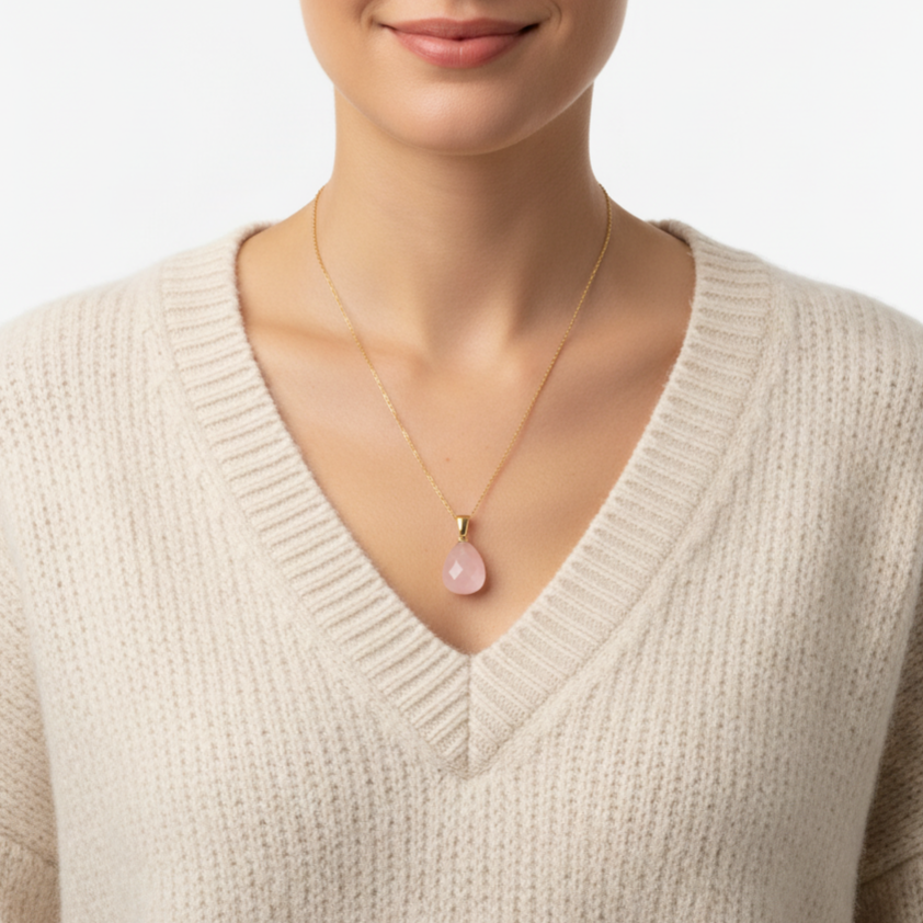 Frau mit beigem Wollpullover trägt eine Halskette aus 585 Gold mit einem Edelsteinanhänger Rosenquarz Tropfen 24 mm