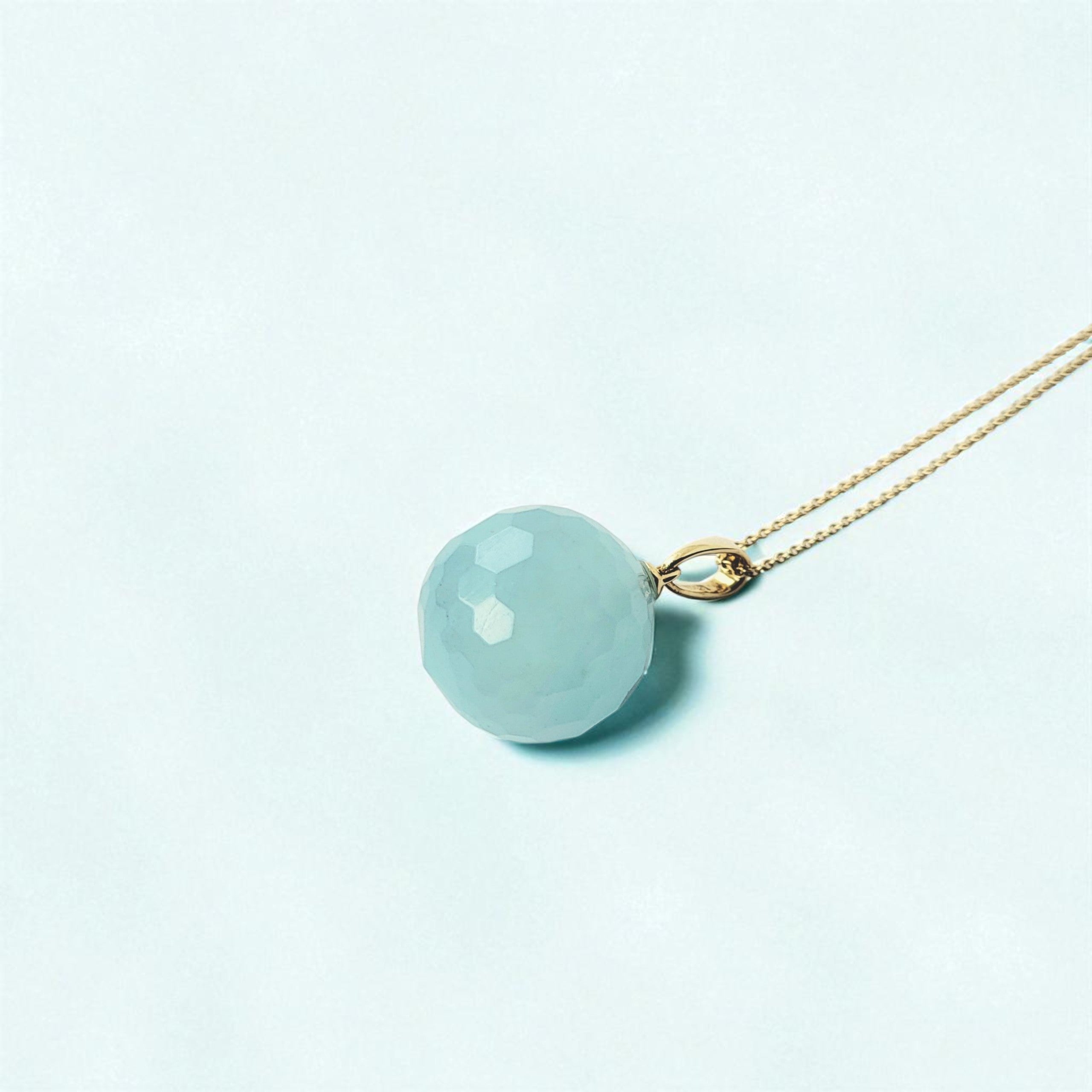 Edelsteinanhänger Aquamarin Kugel 23 mm mit Halskette in 585 Gold auf hellblauen Tisch