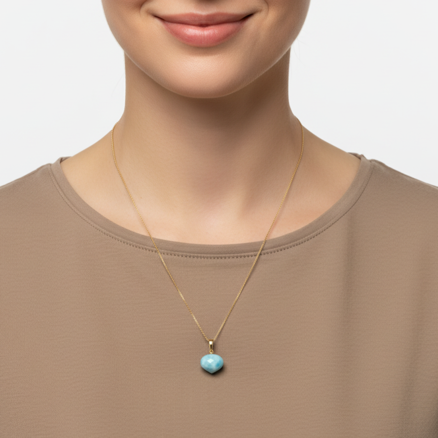 Eine Frau mit hell braunem Shirt trägt eine Halskette aus 585 Gold und einem Edelsteinanhänger aus Larimar in der Form Onion Cut