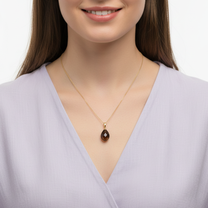 Eine Frau mit lila Bluse trägt eine Halskette aus 585 Gold und einem Edelsteinanhänger aus Rauchquarz
