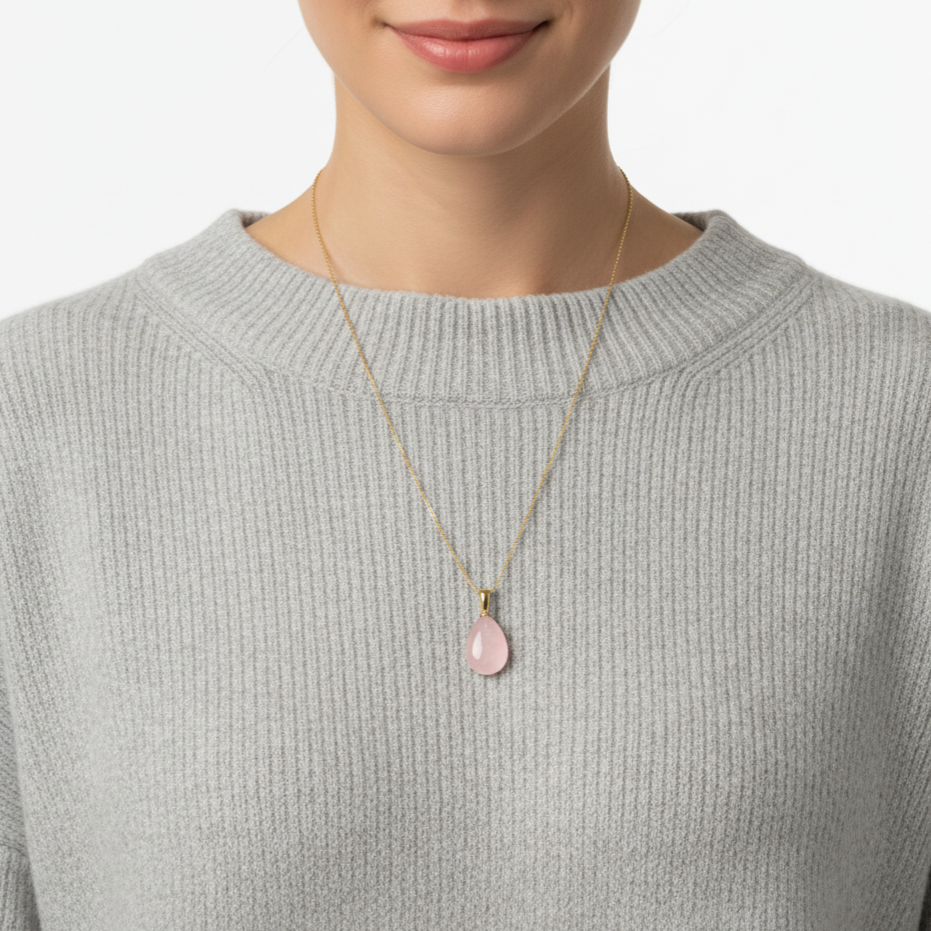 Frau mit grauem Pullover trägt eine Halskette aus 585 Gold mit einem Edelsteinanhänger Rosenquarz Tropfen 24 mm