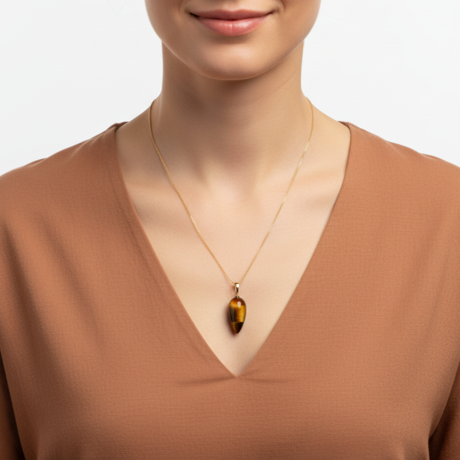 Frau mit terracottafarbender Bluse und Halskette aus 585 Gold mit Edelsteinanhänger Tigerauge Pendel 29 mm